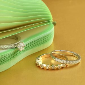 Elegant diamond rings displayed on a gold surface with a chic design.